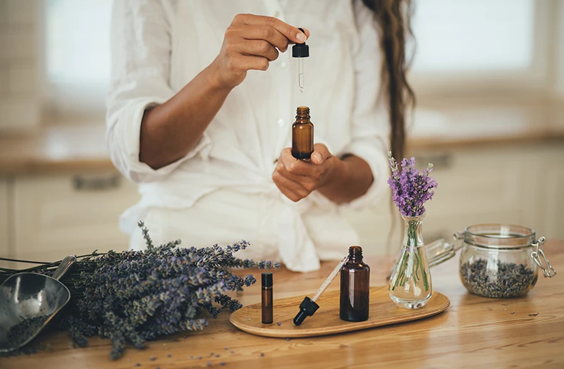 Une femme utilise une pipette pour récupérer de l'huile essentielle